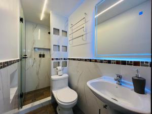 巴尼奥斯Luxury Apartment with Jacuzzi 2 Bedroom 2 Bath的带马桶和水槽的白色浴室 更多11张照片