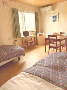 une chambre avec un lit et un bureau avec un ordinateur portable dans l'établissement B&B Ken&Mary, à Biei 45 autres photos