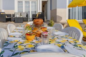 a table with a table cloth with a cake on it at LS Beach House in A dos Cunhados