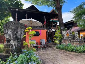 une maison avec un banc devant un bâtiment dans l'établissement Thai Tom s GuestHouse, à Chiang Mai