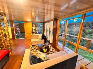 a living room with a couch and some windows at Cabaña arcoiris del lago # 6 in Pasto