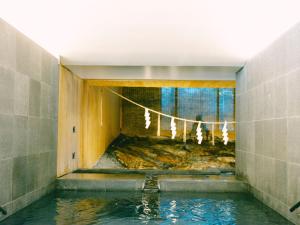 a room with a pool of water in a building at SOIL Nagatoyumoto in Nagato