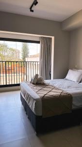 a bedroom with a bed and a large window at Graphite One - Frente metro Luz com Estacionamento in Sao Paulo