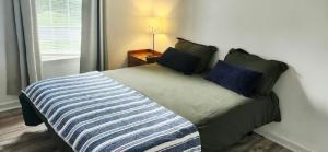 a bedroom with a bed with a blue and white striped blanket at 3bed and 2bath with big backyard quantico Stafford VA home in Stafford