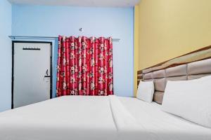 a bedroom with a bed and a red curtain at Hotel O Knight guest house in Morādābād