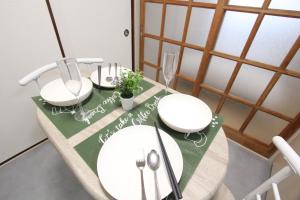 a table with two white chairs and a green table cloth at HOTEL LUANA in IKEBUKURO HIGASHINAGASAKI in Tokyo +156 photos
