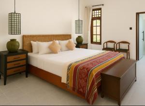 a bedroom with a large bed and two chairs at Villa Andia in Gili Air