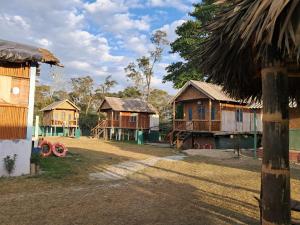 um grupo de cabanas de madeira em uma aldeia em Dibru-Saikhowa Homestay em Tinsukia