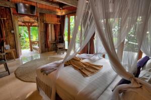 une chambre avec un lit avec moustiquaire dans l'établissement Sweet Orange Pondok, à Ubud 96 autres photos