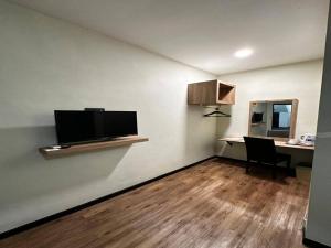 a living room with a desk and a flat screen tv at Collection O Malacca Near St John's Fort Formerly Gill Garden in Melaka
