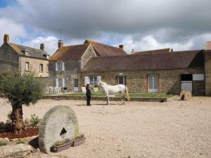 a man with a horse in front of a house at Maison avec jardin et animaux admis au cœur d'un haras - FR-1-497-43 in Montabard