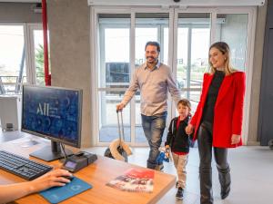 a woman and a man and a child walking in an office at ibis Guarapuava in Guarapuava