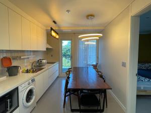 a kitchen with a table and chairs in a room at 뚠하우스3 in Samgong