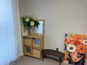 a room with a vase of flowers on a mirror at 뚠하우스3 in Samgong