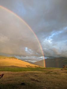 a rainbow in the sky over a field at Beautiful Dome for a Romantic Glamping Escape with Breathtaking Views in Montana in Plains