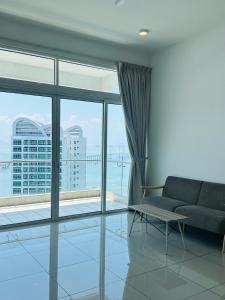 a living room with a couch and a large window at Seaview Condo A31 #Queensbay#SPICE in Bayan Lepas