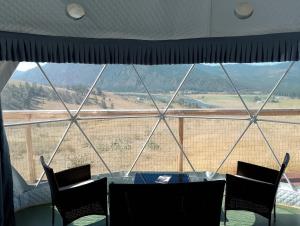 a table and chairs in front of a large window at Beautiful Dome for a Romantic Glamping Escape with Breathtaking Views in Montana in Plains