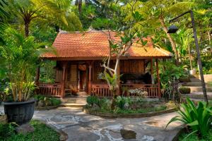 une petite maison au milieu d'un jardin dans l'établissement Sweet Orange Pondok, à Ubud