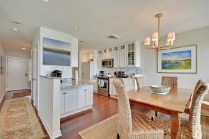 een keuken en eetkamer met een houten tafel en stoelen bij WS4463: 4463 Windswept in Kiawah Island