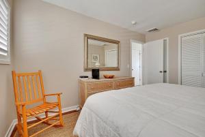 a bedroom with a bed and a chair and a mirror at WS4463: 4463 Windswept in Kiawah Island