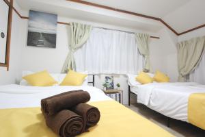 a bedroom with two beds with towels on them at HOTEL LUANA in IKEBUKURO HIGASHINAGASAKI in Tokyo