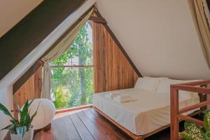 Un dormitorio con una cama y una ventana grande en THE LOFT - Super Central General Luna, en General Luna