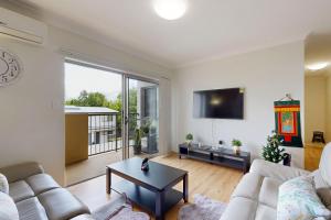 a living room with a couch and a table at Sweet Mango Hill Apartment w Convenient Location in North Lakes