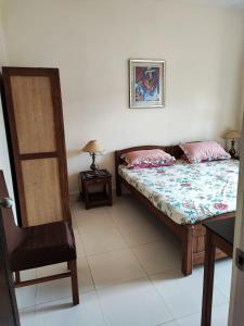a bedroom with a bed and a table and a chair at Villa Candolim Goa in Candolim +3 photos
