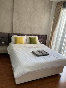 ein weißes Bett mit einem Tablett darauf in der Unterkunft I-City Premier Suites Shah Alam by Landmark in Shah Alam