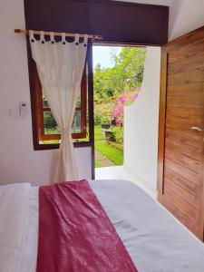 a bedroom with a bed and a window at GYANA House in Ubud