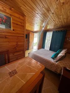 a bedroom with a bed in a wooden cabin at Cabañas Sol de Buchupureo in El Cerrillo