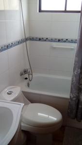 a white bathroom with a toilet and a sink at Cabañas Sol de Buchupureo in El Cerrillo