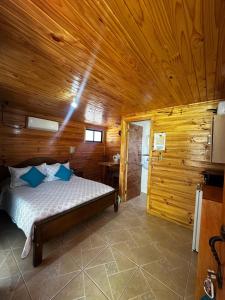 a bedroom with a bed in a wooden cabin at Cabañas Sol de Buchupureo in El Cerrillo
