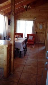 a dining room with a table and chairs in a cabin at Cabañas Sol de Buchupureo in El Cerrillo