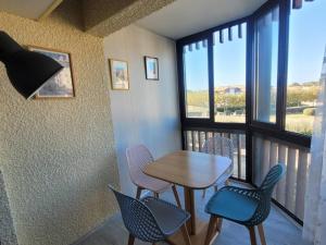 a dining room with a table and chairs and a balcony at Charmant T2 à Vieux-Boucau, 4 pers, parking - FR-1-857-5 in Vieux-Boucau-les-Bains