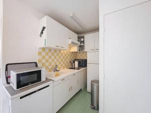 a small kitchen with white cabinets and a microwave at Charmant T2 à Vieux-Boucau, 4 pers, parking - FR-1-857-5 in Vieux-Boucau-les-Bains +2 photos