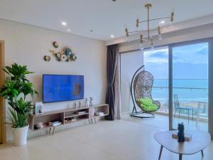 a living room with a tv and a large window at Căn Hộ The Sóng Condotel Vũng Tàu - Hao'sHomestay in Vung Tau