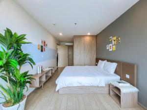 a bedroom with a bed and a potted plant at Căn Hộ The Sóng Condotel Vũng Tàu - Hao'sHomestay in Vung Tau