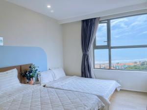 a bedroom with two beds and a large window at Căn Hộ The Sóng Condotel Vũng Tàu - Hao'sHomestay in Vung Tau +76 photos