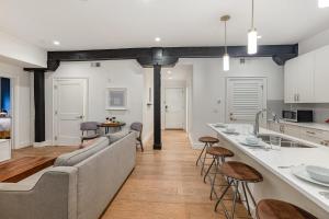 ナッシュビルにあるThe Saddlery - Spotlight - 2 Min Walk to Broadwayのオープンキッチンとソファとバーのあるリビングルーム