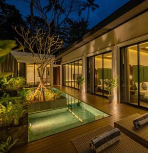 a house with a swimming pool at night at Lovely 3 Bedroom Villa in Ubud - Artha Loka OA in Ubud