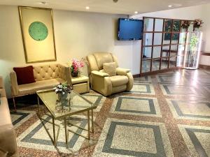 a living room with two chairs and a tv at City Lodge Bangkok in Bangkok