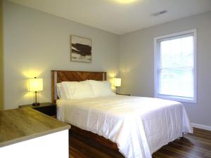 Un dormitorio con una cama con sábanas blancas y una ventana. en Quiet and Comfortable 2 BD Duplex, en Salem