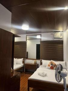 a bedroom with a bed with a fan and a mirror at BALAI MALINAWON Hotel Room 2 in General Luna