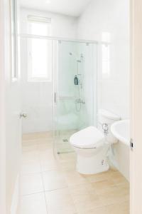 Un baño blanco con inodoro y ducha. en Xing Yu Hotel, en Mao-i-san-ts'un