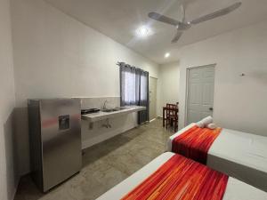 ティシミンにあるDepartamento AF 1のベッド2台、シンク、冷蔵庫が備わる客室です。