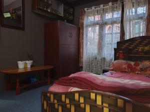 a bedroom with a bed and a table and a window at Sanjog's B&B in Bhaktapur