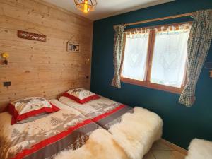 ein Schlafzimmer mit einem Bett und einem Fenster mit zwei Kissen in der Unterkunft Appartement chaleureux 4 pièces, 5 pers, parking - FR-1-676-239 in Châtel
