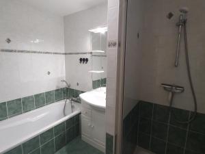 ein Badezimmer mit Badewanne, Waschbecken und Dusche in der Unterkunft Appartement chaleureux 4 pièces, 5 pers, parking - FR-1-676-239 in Châtel