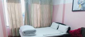 a room with a bed and a window with towels at Sanjog's B&B in Bhaktapur